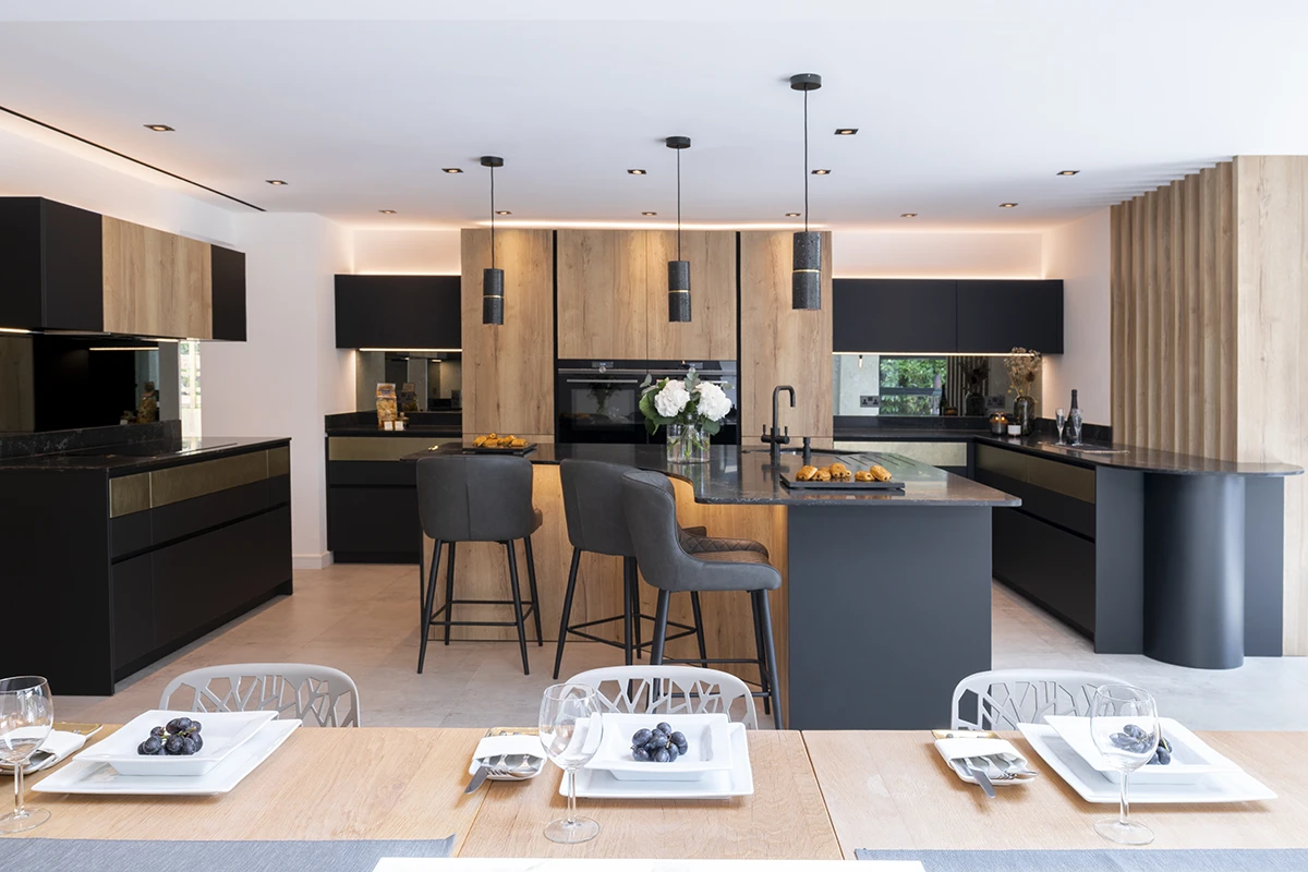 Open-plan kitchen with dark cabinets, timber accents and island pendant lights