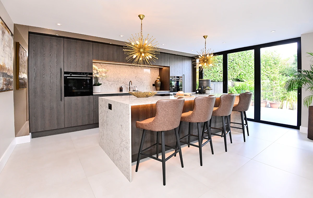 Modern kitchen with white island, upholstered stools and dark wood cabinetry